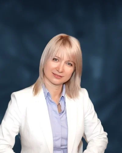 Nika Mak performance mindset coach white jacket with dark blue green background