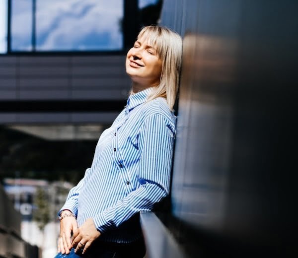 Nika Mak performance mindset coach in light blue striped shirt outside new the wall for mobile